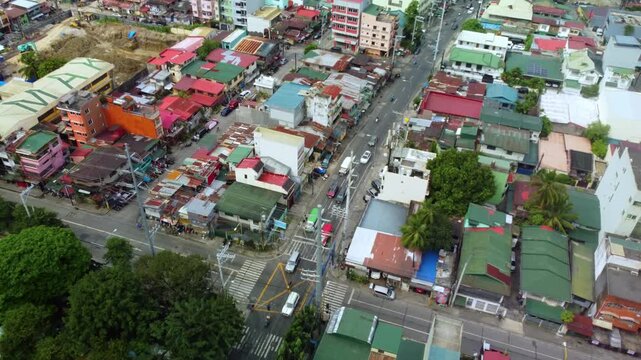 Aerial view of a dense urban cityscape with colorful buildings and busy streets showing constant traffic.