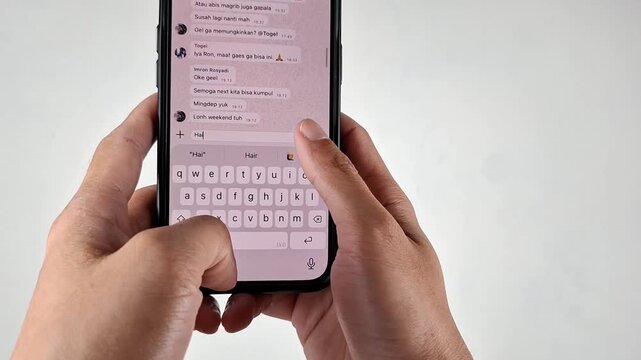 Asian male hands texting on his mobile phone using bahasa on isolated background