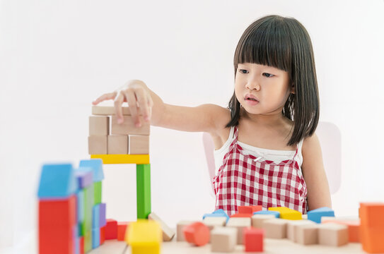 Little asian girl hands play blocks in classroom. Learning by playing education group study concept. International pupils do activities brain training in primary school background banner