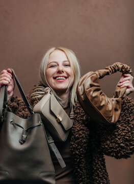 A stylish blonde woman wearing a teddy coat paired with vintage bags, standing against a rich brown background in shade Mocha Mousse
