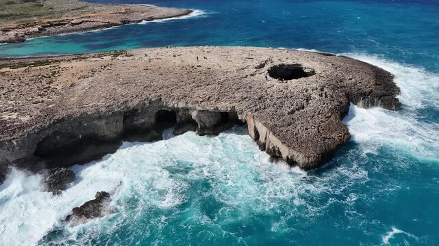 sea caves undercut limestone cliff base malta coral lagoon blowhole rock roof turquoise water crashes rugged coastline aerial drone footage karst erosion mediterranean natural pool geology dramatic