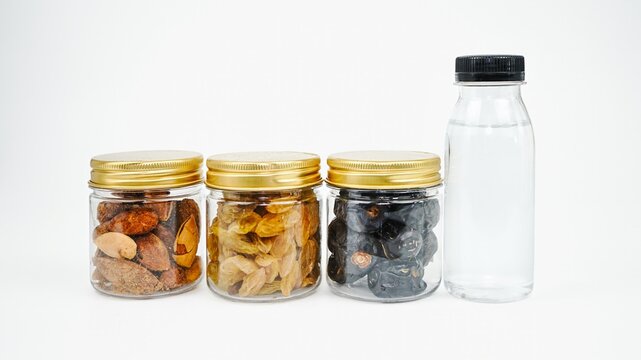 Mixed nuts dried fruits glass jars water bottle isolated background