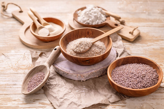 Psyllium husk and powder, xanthan and guar gum in wooden bowls and spoons on a rustic table