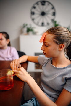 Girl playing guessing game with sticky note on forehead