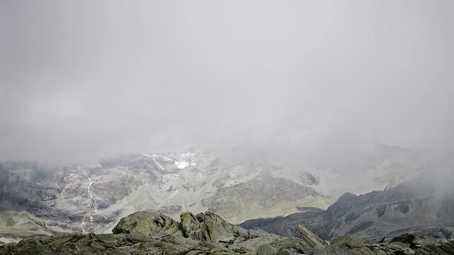 Among the clouds on the top of Sasso Nero, beautiful peak with amazing view towards Bernina massif
