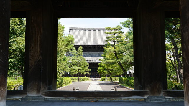 Traditional Japanese temple framed by a wooden gate in Kyoto