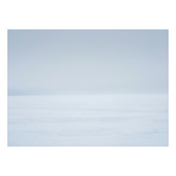 Un paesaggio invernale minimalista caratterizzato da una distesa di neve bianca incontaminata che si fonde con un cielo grigio nebbioso all'orizzonte, creando un'atmosfera serena e astratta.