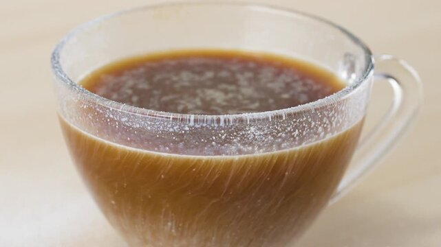 Hot Black Coffee with Dairy Alternative Swirling in Glass Mug