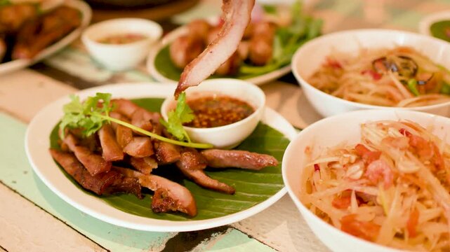 Thai Grilled Pork Jowl Served with Papaya Salad and Dipping Sauce