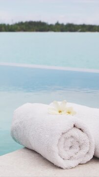 Spa wellness Luxury vacation with towel by infinity pool hotel resort. Raw unedited vertical video.