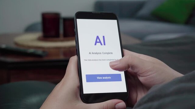 Close-up of a user viewing an AI Analysis Complete alert on a phone app with a blue View analysis button in a casual living room setting.