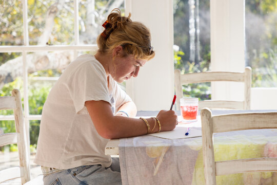 young woman drawing at table in light filled room