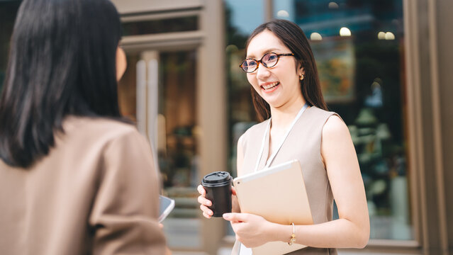 Two young adult business woman talking teamwork communication