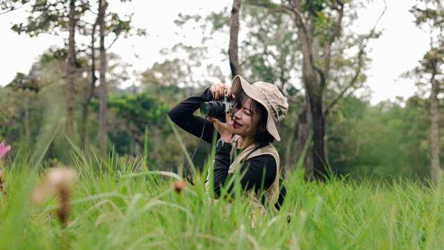 Two female hikers with backpacks pointing at scenery while exploring a lush green forest trail.