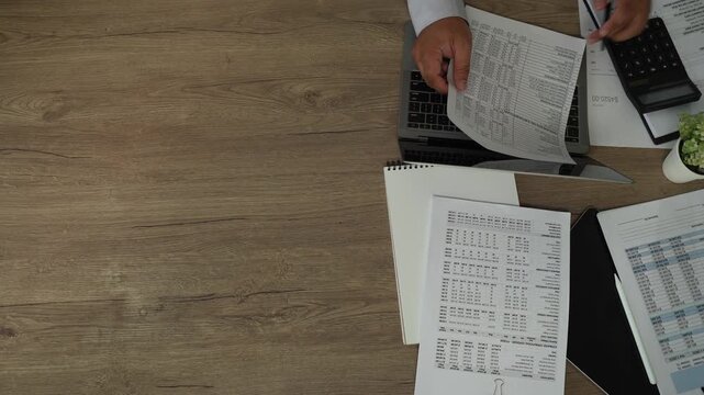 Accountant reviewing financial reports with laptop, calculator, tablet, pen for accounting, tax preparation, audit, bookkeeping, financial planning with wide copy space.