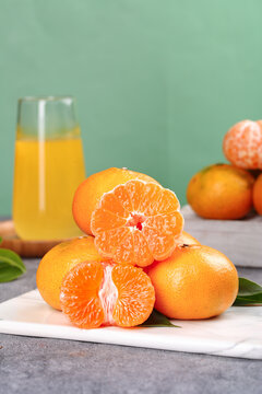 Fresh Citrus Oranges and Orange Juice on Marble Counter with Green Background