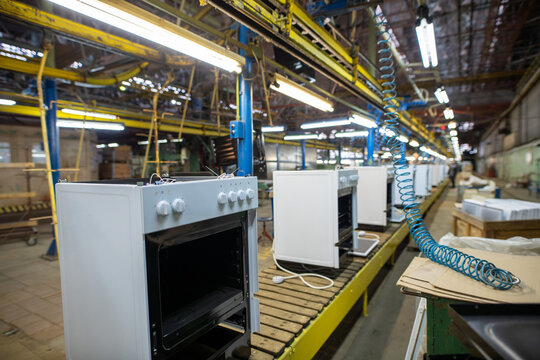 White ovens on factory assembly line under industrial lighting