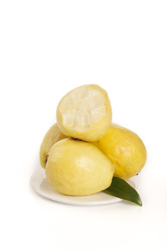 Fresh Yellow Guava Fruits with Cream Flesh on White Plate - Tropical Exotic Fruit