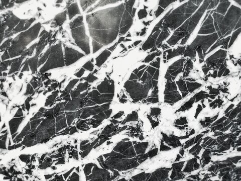 This photo shows a dark-colored marble surface with naturally occurring white veins spreading across it.