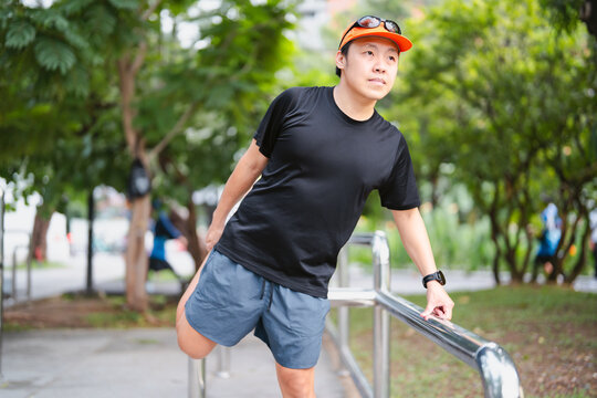 Adult asian man runner stretching kneel and leg wear sports outfit training for running marathon challenge workout
