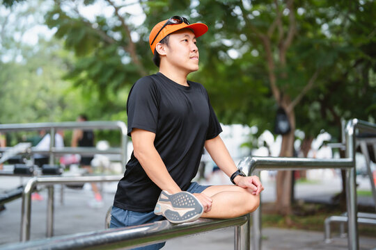 Adult asian man runner stretching kneel and leg wear sports outfit training for running marathon challenge workout