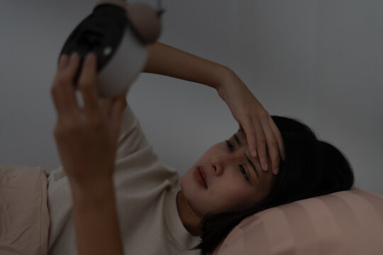 man in bed late trying to sleep suffering insomnia, sleepless or scared in a nightmare, looking sad worried and stressed. Tired and headache or migraine waking up in the middle of the night.
