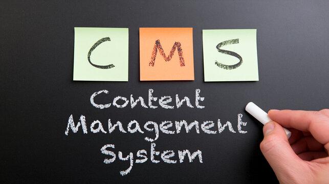 A hand writes Content Management System with chalk on a blackboard beneath sticky notes. This visual concept illustrates digital website administration and business software.