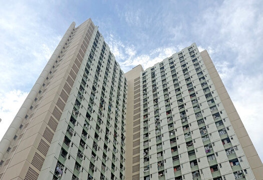 Hong Kong Towering residential building with many windows against cloudy sky