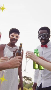 Animation of christmas stars over diverse friends wearing masks at party and making toast