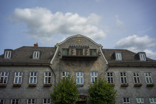Historic town hall building facade with slate tiles and golden clock in Clausthal-Zellerfeld