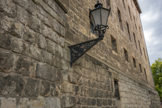 Vintage wrought iron street lamp on historic stone building wall