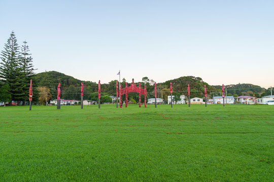 Carved red pou (posts) standing in a grassy field Located near Waitangi and Paihia in the Bay of Islands