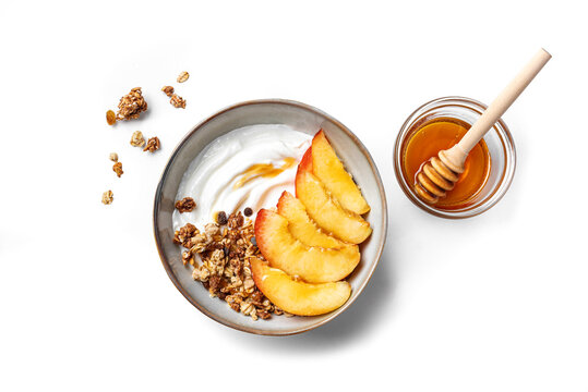 Granola bowl with yogurt, peach, and honey isolated