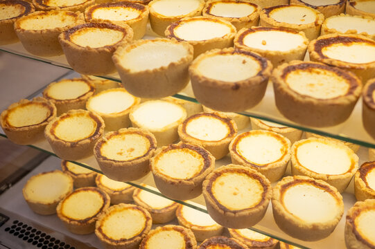 Rows of delicious custard tarts on display in bakery shop