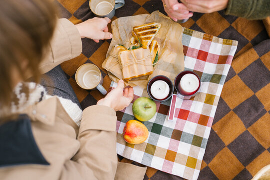 Cozy autumn picnic with sandwiches and candles on plaid blanket