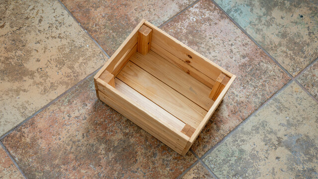 Wooden box on tiled floor with natural texture