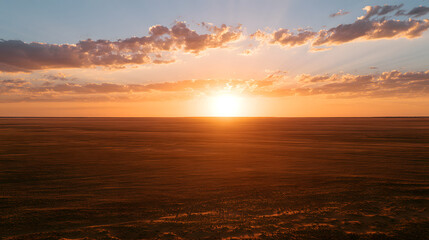 Fototapeta premium Golden Hour Light Over Red Outback Plains with Warm Amber Glow and Dramatic Cloud Formation