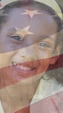 Animation of usa flag over happy african american girl smiling at camera
