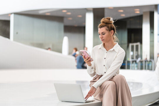 Businesswoman working remotely in a modern lobby
