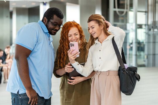 Diverse business friends laughing together at a smartphone