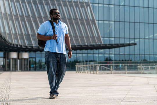 Confident Black man walking through a modern city