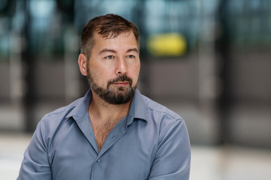confident, serious, bearded man looks straight ahead.