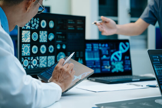 Asian medical team reviews healthcare data, medication samples and digital reports during a clinical meeting, highlighting teamwork, research