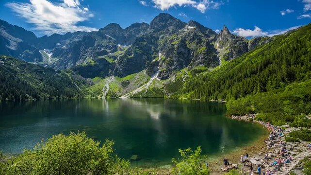 Scenic view of Morskie Oko lake and Tatra mountains in Poland during sunny summer day.