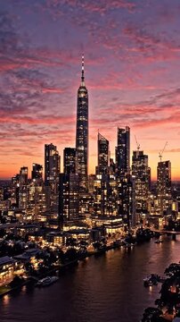 Modern City Skyline at Sunset with Dramatic Clouds - A stunning aerial view of a modern city skyline illuminated at sunset, with vibrant pink and orange clouds painting the sky.