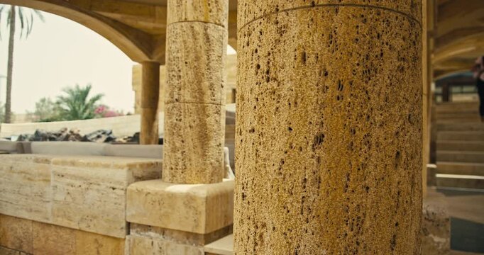 Close up of weathered limestone columns and stone architecture in warm daylight, highlighting natural texture, craftsmanship, and architectural detail.