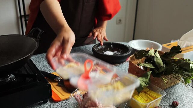 Chef adding seasonings and grinding spices with mortar and pestle for cooking