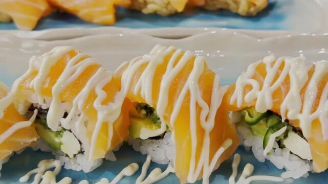 Close-up of California roll sushi arranged on a serving plate, featuring rice, seafood, avocado, and fresh ingredients with an elegant presentation.