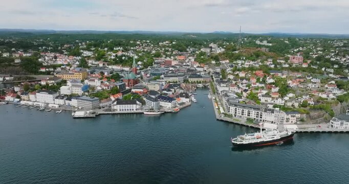 Aerial view of Arendal harbor town Norway waterfront in slow motion showing temperate climate