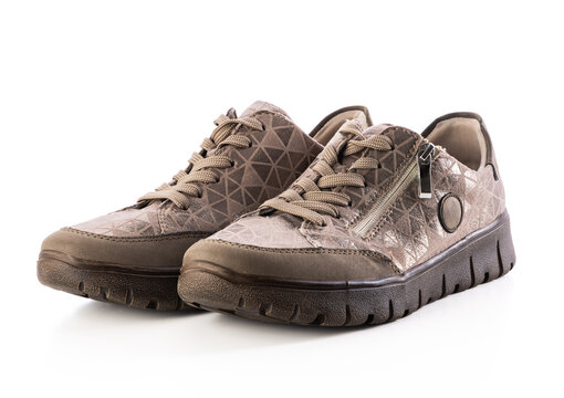 Pair of women beige casual sneakers with side zipper isolated on white background